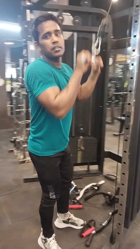 A member using a cable and pulley station on the gym floor